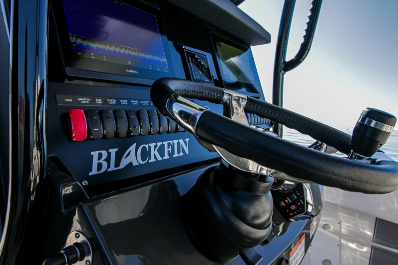 Slide: The Image of 2023 Blackfin 272 CC boat dashboard with steering wheel and control panel. - 14