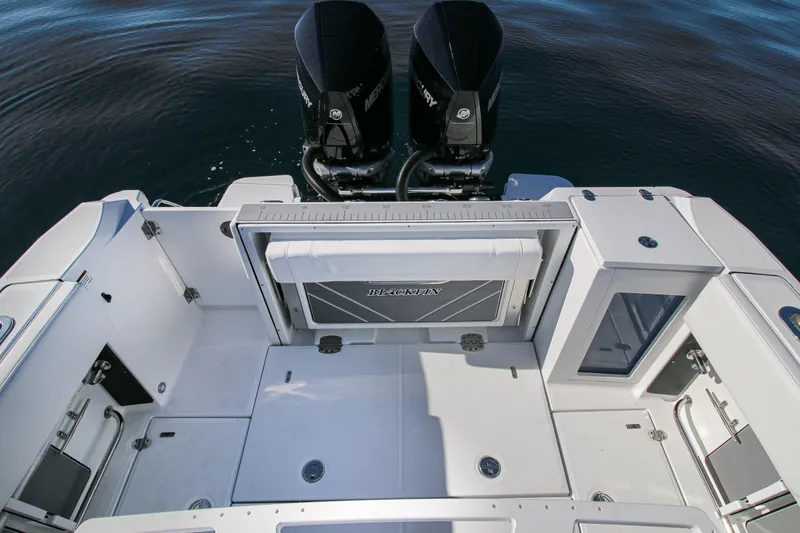 Slide: The Image of 2023 Blackfin 272 CC boat deck with dual outboard engines, spacious layout, and modern design. - 17