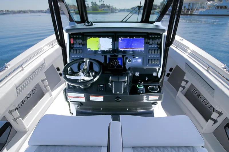 Slide: The Image of 2023 Blackfin 302 CC boat cockpit with advanced navigation system and steering wheel. - 15