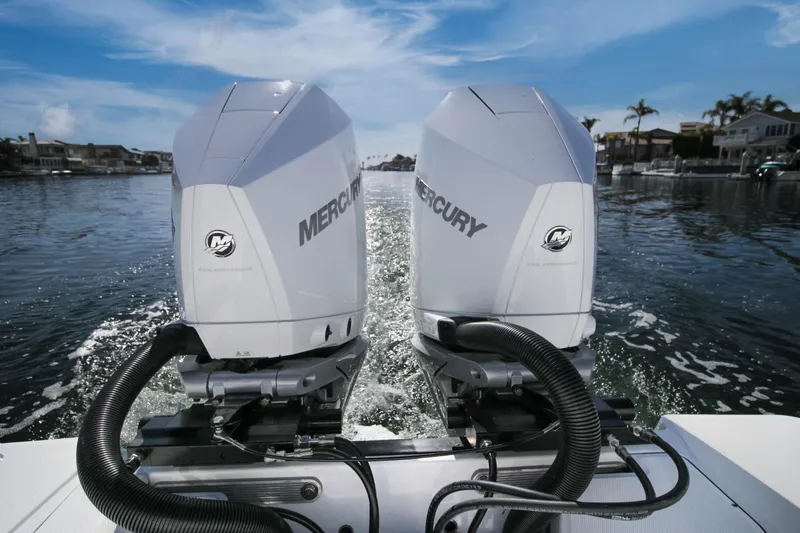 Slide: The Image of Twin Mercury outboard engines on a 2023 Blackfin 302 CC boat, cruising on a sunny day. - 23