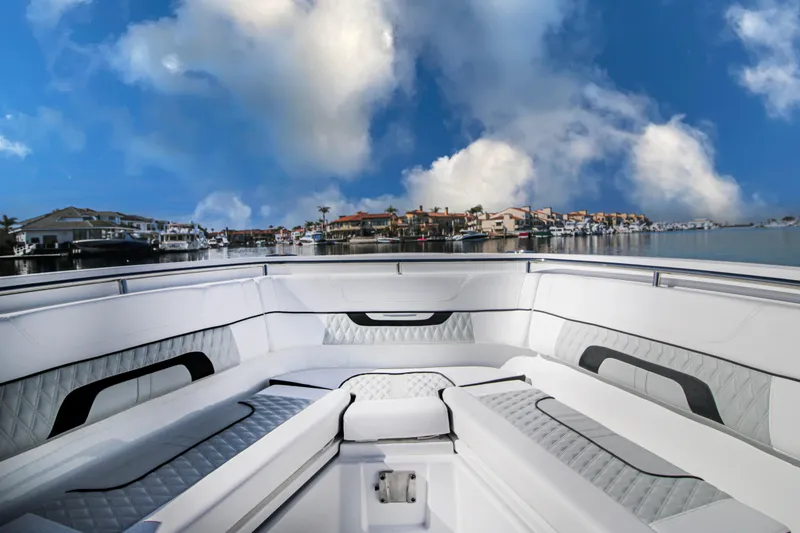 Slide: The Image of 2023 Blackfin 302 CC boat interior with luxurious seating, under a vibrant blue sky. - 6