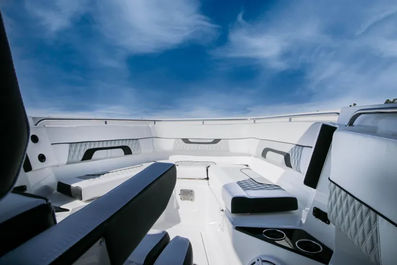 Slide: The Image of 2023 Blackfin 302 CC boat interior with luxurious seating under a clear blue sky. - 7