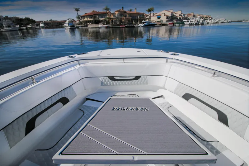 Slide: The Image of 2023 Blackfin 302 CC boat interior with waterfront view, featuring sleek seating and table. - 9