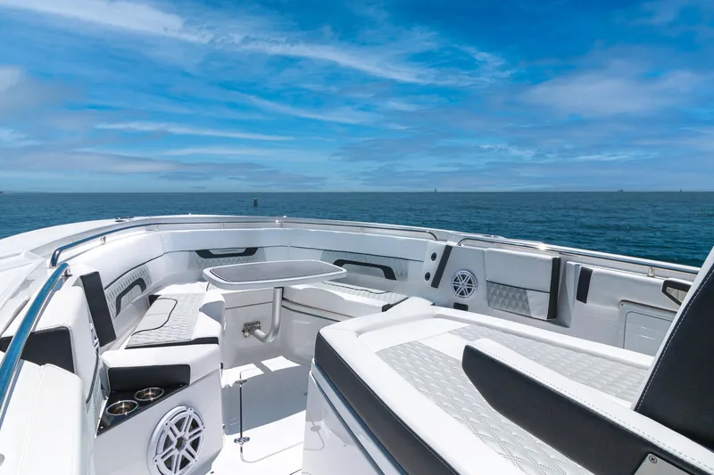 Slide: The Image of 2024 Blackfin 332 CC boat interior with seating, table, and ocean view. - 2