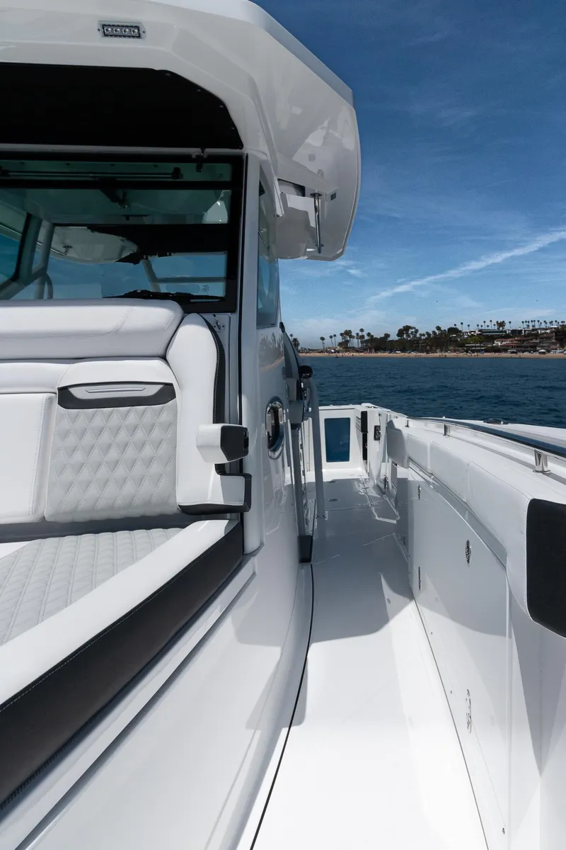 Slide: The Image of 2024 Blackfin 332 CC boat, sleek design, white interior, ocean backdrop, clear blue sky. - 3