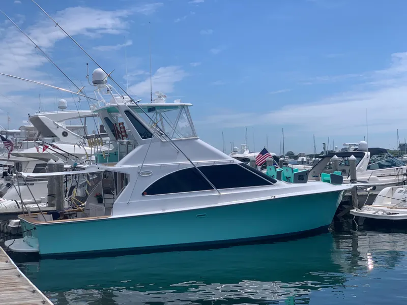 The Image of 1993 Ocean Yachts 42 Flybridge docked in a marina under a clear blue sky. - 0
