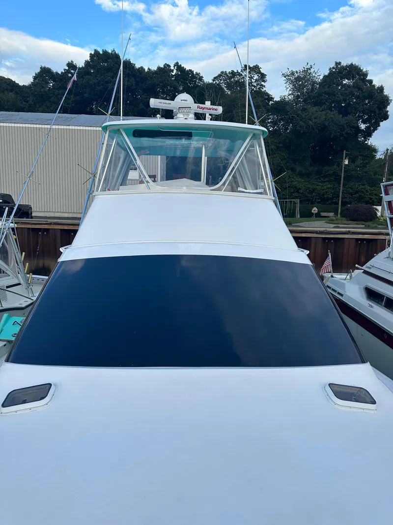 Slide: The Image of 1993 Ocean Yachts 42 Flybridge with sleek design, docked under a blue sky. - 11