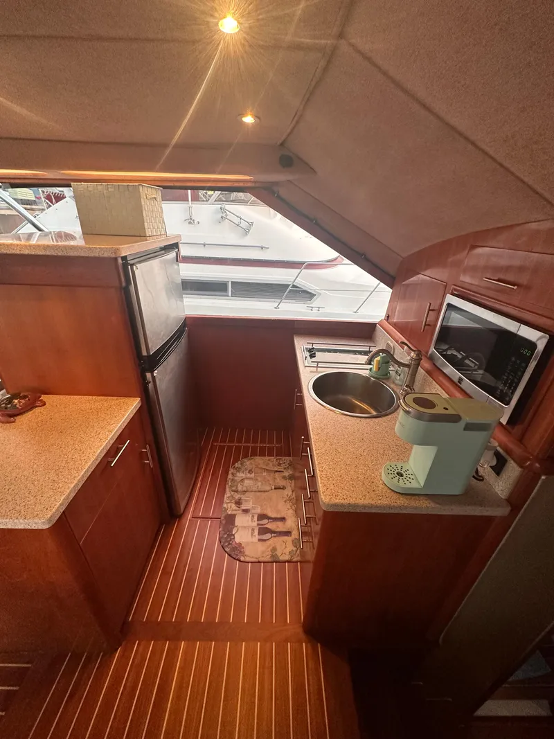 Slide: The Image of Interior of 1993 Ocean Yachts 42 Flybridge kitchen with modern appliances and wood finish. - 14
