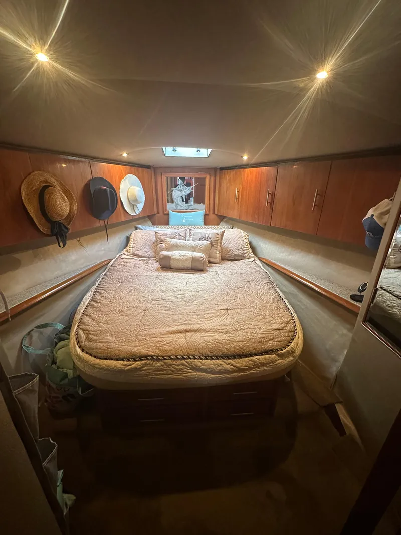 Slide: The Image of Cozy bedroom in 1993 Ocean Yachts 42 Flybridge with hats and warm lighting. - 16