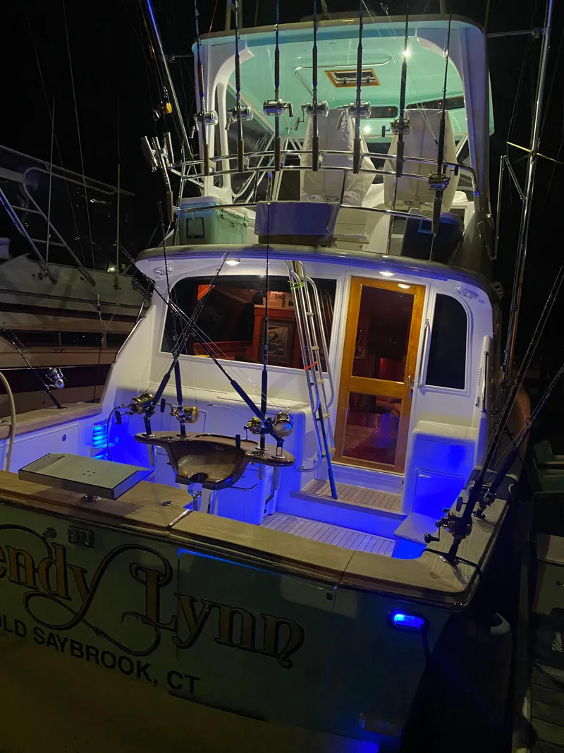 Slide: The Image of 1993 Ocean Yachts 42 Flybridge with illuminated deck and fishing rods at night. - 2