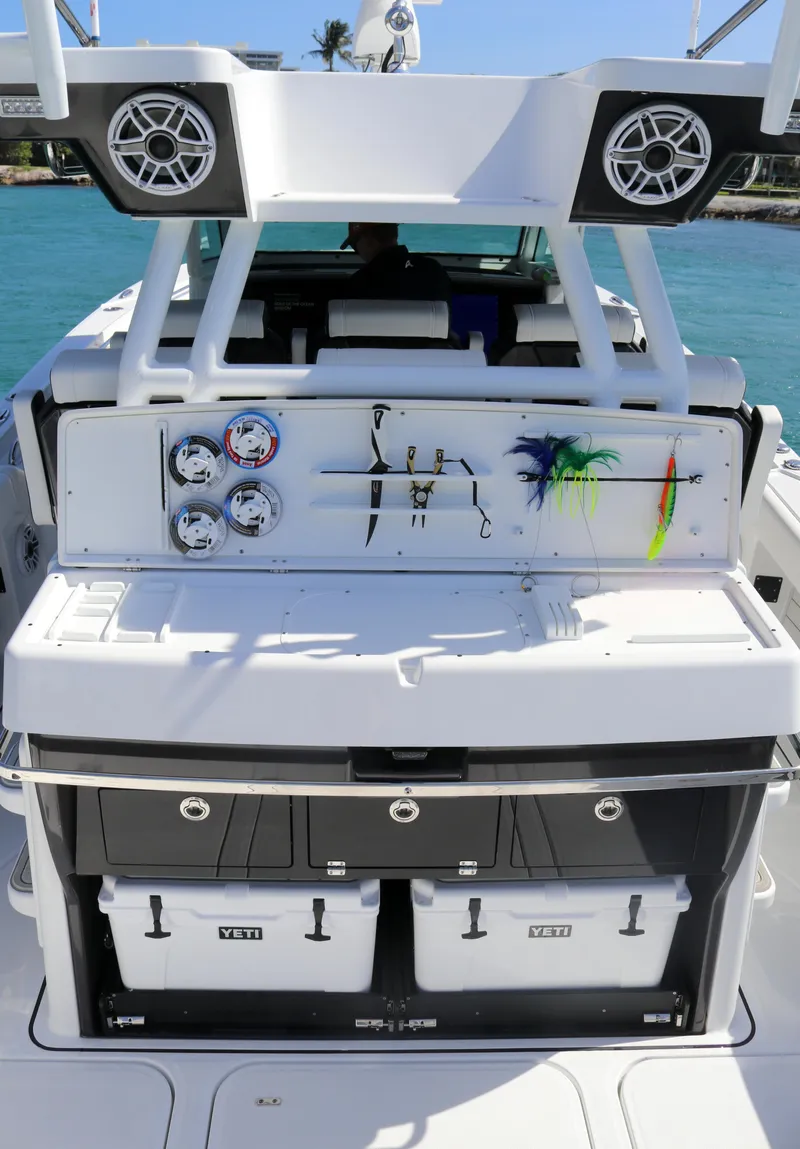 Slide: The Image of 2025 Blackfin 400 CC boat with fishing gear and storage, docked by turquoise water. - 13