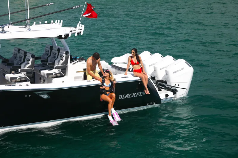 Slide: The Image of 2025 Blackfin 400 CC boat with people enjoying water activities. - 6
