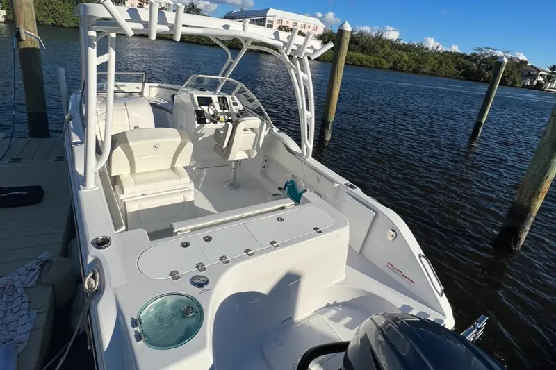 Slide: The Image of 2024 Century Resorter boat docked on a sunny day, featuring spacious seating and modern controls. - 3