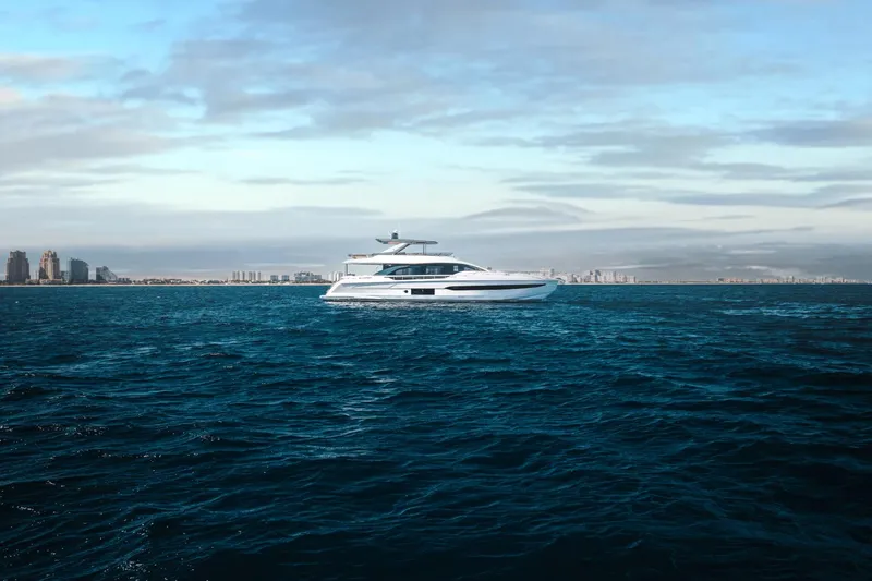 Slide: The Image of 2024 Azimut Fly 78 yacht cruising on open water with city skyline in the background. - 11