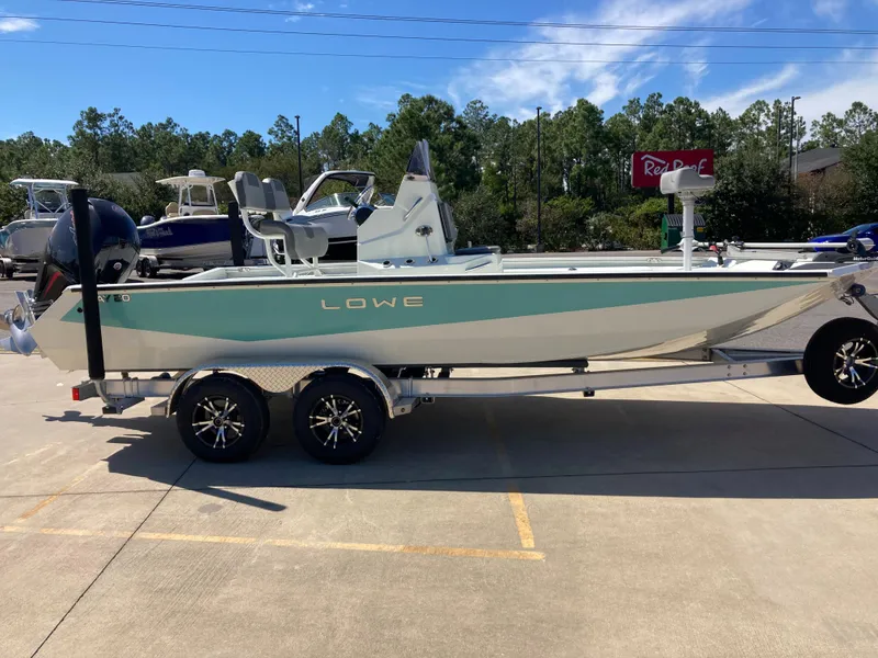 Slide: The Image of 2022 Lowe BAY 20 boat on a trailer in a parking lot. - 17