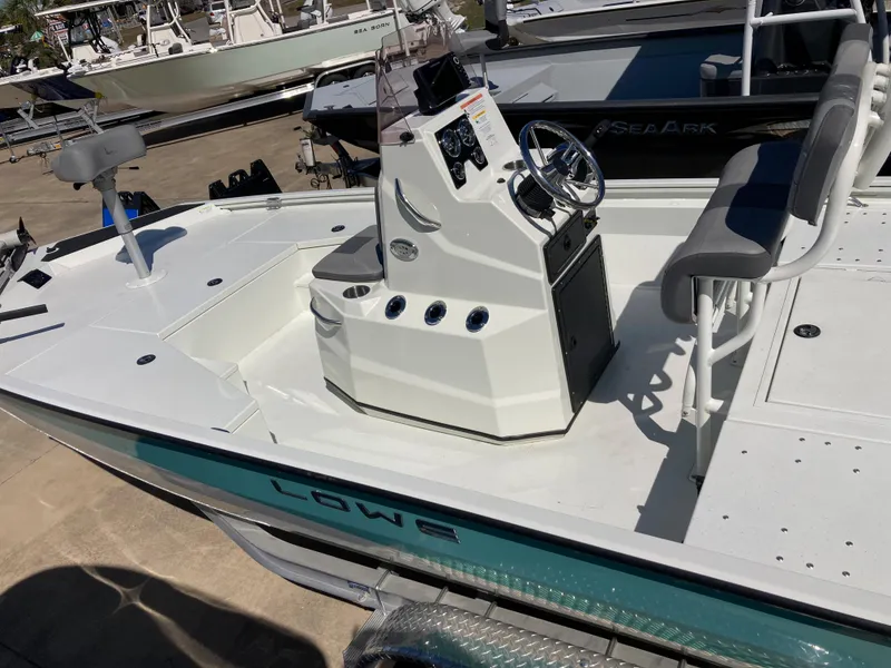 Slide: The Image of 2022 Lowe BAY 20 boat with center console and seating, docked at a marina. - 4