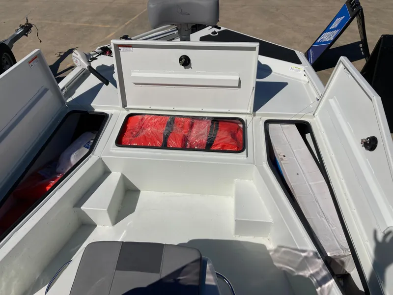 Slide: The Image of 2022 Lowe BAY 20 boat storage compartments with life jackets and seating. - 7