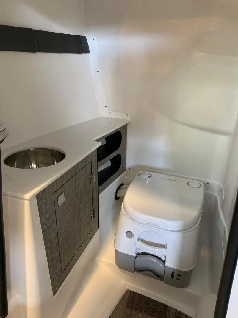 Slide: The Image of 2024 Monterey 258 Super Sport boat interior bathroom with sink and portable toilet. - 9