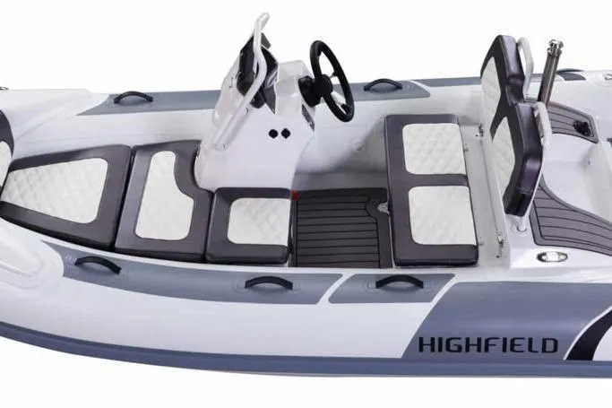 The Image of 2026 Highfield Sport 330 boat interior with white and gray seating, steering console, and modern design. - 3