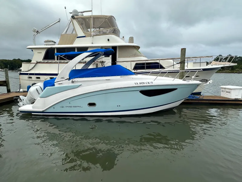 Slide: The Image of 2022 Regal 26XO boat docked at marina with blue cover. - 10