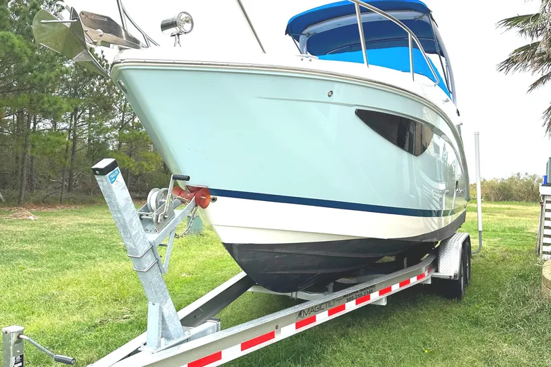 Slide: The Image of 2022 Regal 26XO boat on trailer, parked on grass. - 12