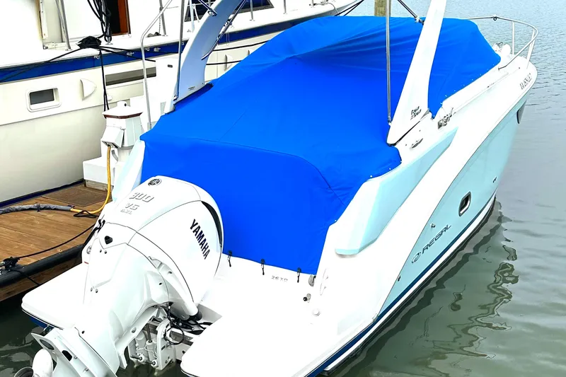 Slide: The Image of 2022 Regal 26XO boat with blue cover docked, featuring a Yamaha outboard motor. - 16