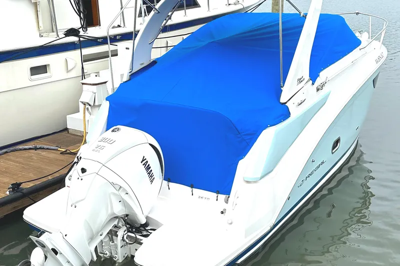 Slide: The Image of 2022 Regal 26XO boat with blue cover and Yamaha outboard motor docked. - 19