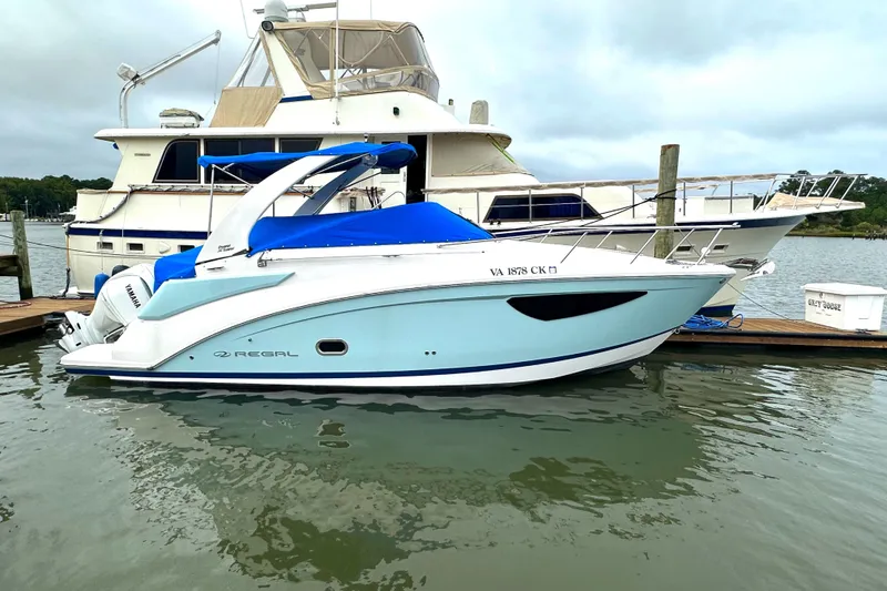Slide: The Image of 2022 Regal 26XO boat docked at marina with blue cover. - 21