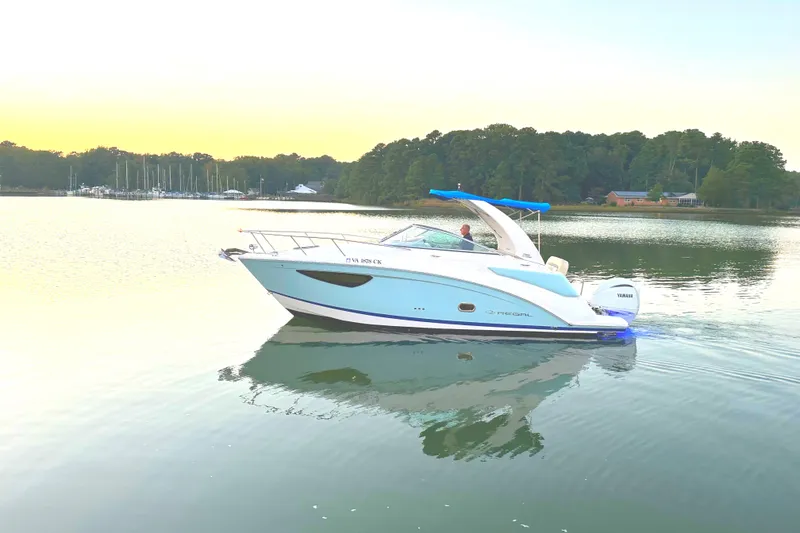 Slide: The Image of 2022 Regal 26XO boat cruising on a calm lake at sunset. - 25