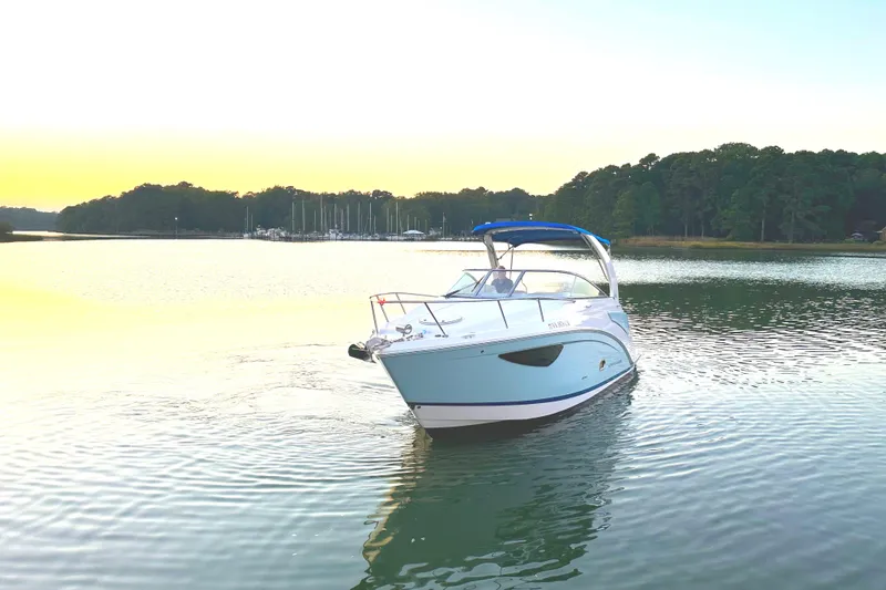 Slide: The Image of 2022 Regal 26XO boat cruising on a serene lake at sunset. - 27