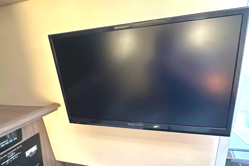 Slide: The Image of Flat-screen TV in the cabin of a 2022 Regal 26XO boat. - 35