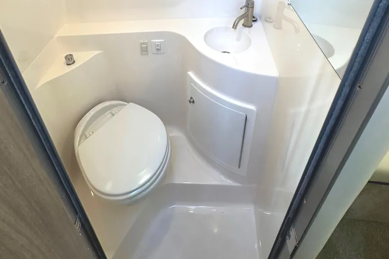 Slide: The Image of 2022 Regal 26XO boat bathroom with toilet, sink, and storage cabinet. - 36