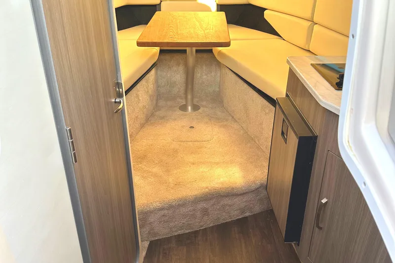 Slide: The Image of 2022 Regal 26XO cabin interior with beige seating and wooden table. - 37