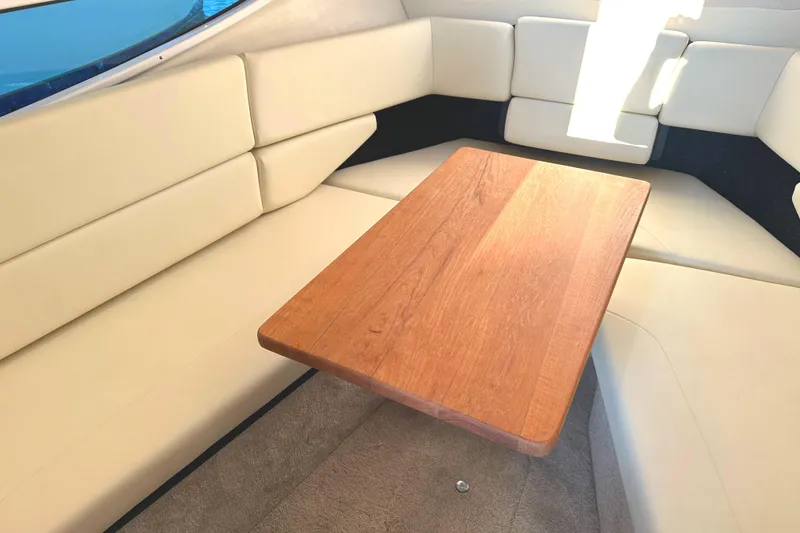 Slide: The Image of 2022 Regal 26XO boat interior with beige seating and wooden table. - 38
