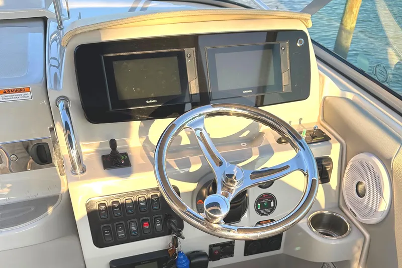 Slide: The Image of 2022 Regal 26XO boat dashboard with dual displays and steering wheel. - 39