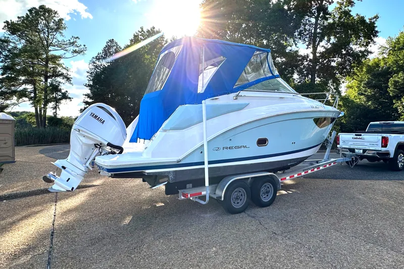 Slide: The Image of 2022 Regal 26XO boat on trailer with Yamaha outboard motor, parked outdoors. - 48