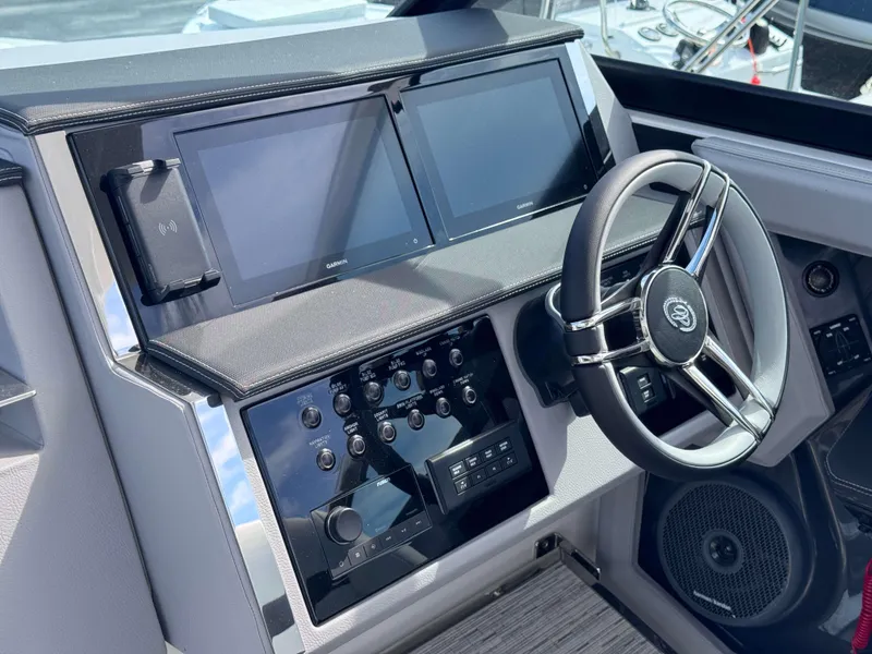 Slide: The Image of 2024 Cobalt R33 boat dashboard with dual Garmin screens and modern steering wheel. - 16