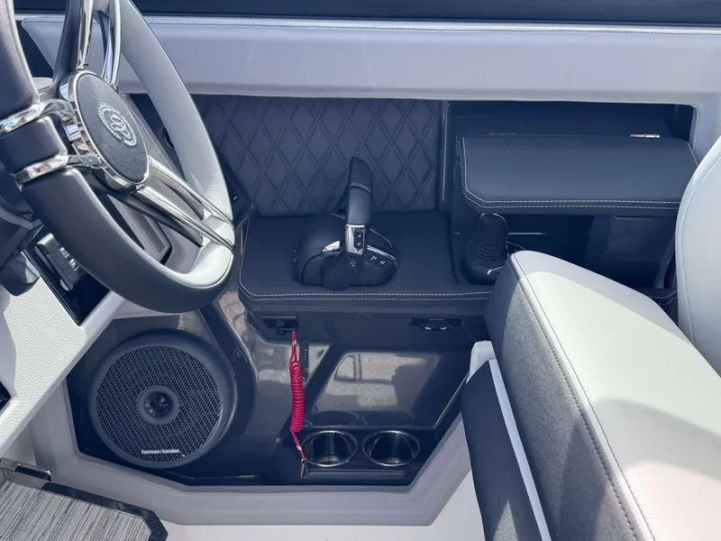 Slide: The Image of 2024 Cobalt R33 boat cockpit with steering wheel, control panel, and Harman Kardon speaker. - 17