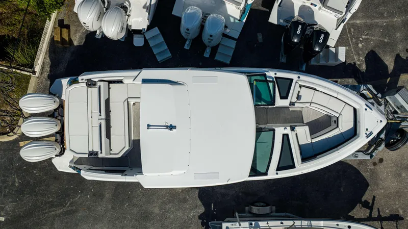 Slide: The Image of Top view of a 2024 Cobalt R33 boat with triple outboard engines. - 23