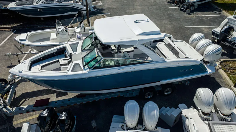 Slide: The Image of 2024 Cobalt R33 boat with triple Yamaha outboard engines on a trailer. - 24
