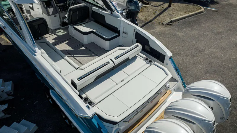 Slide: The Image of 2024 Cobalt R33 boat interior with seating and triple Yamaha outboard engines. - 28