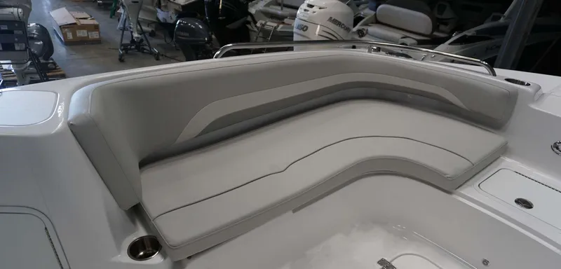 Slide: The Image of 2024 Hurricane 231 SS boat interior with gray cushioned seating in a showroom. - 13