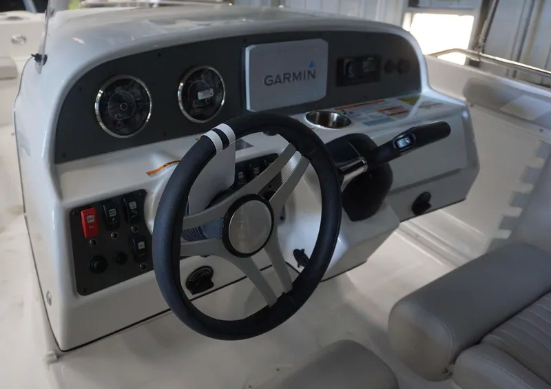 Slide: The Image of 2024 Hurricane 231 SS boat dashboard with Garmin navigation system and steering wheel. - 8