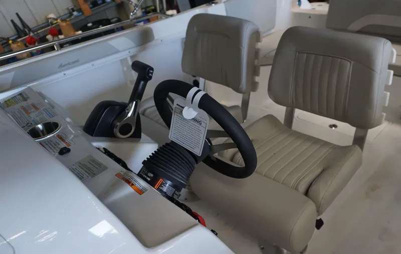 Slide: The Image of 2024 Hurricane 231 SS boat cockpit with steering wheel and beige seats. - 9