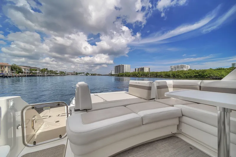Slide: The Image of 2013 Sea Ray 450 Sundancer yacht with spacious deck, overlooking serene waterfront and skyline. - 17
