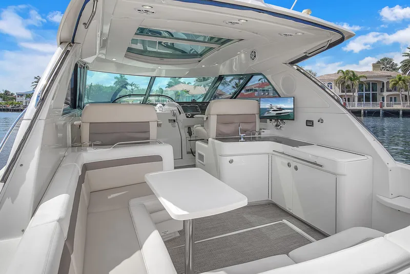 Slide: The Image of 2013 Sea Ray 450 Sundancer yacht interior with seating, table, and waterfront view. - 19