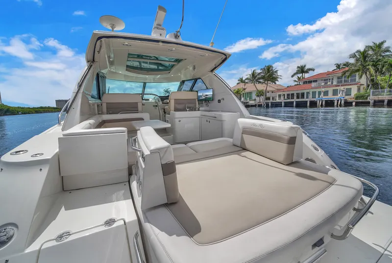 Slide: The Image of 2013 Sea Ray 450 Sundancer yacht with spacious deck, docked near waterfront homes. - 27