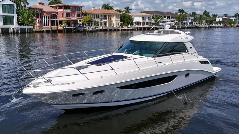 Slide: The Image of 2013 Sea Ray 450 Sundancer yacht cruising on a scenic waterfront. - 5