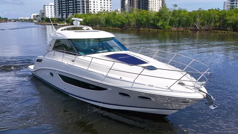 Slide: The Image of 2013 Sea Ray 450 Sundancer yacht cruising on a calm river near urban skyline. - 7