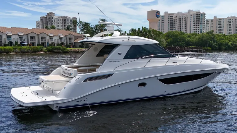 Slide: The Image of 2013 Sea Ray 450 Sundancer yacht on calm water, with cityscape background. - 8